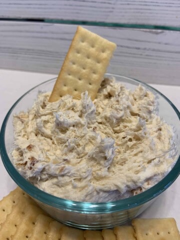 Smoked Fish Dip in a small glass bowl with a club cracker stuck in the top of the dip.