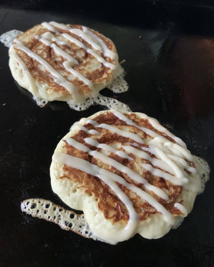 Cinnamon Swirl Pancakes on Griddle with Zig-Zag Icing