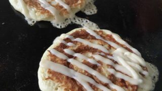 Cinnamon Swirl Pancakes on Griddle with Zig-Zag Icing