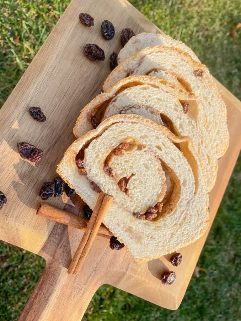 Sliced Cinnamon Raisin Bread on a wooden base board.