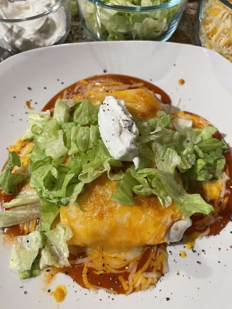 Wet Burrito topped with lettuce and sour cream