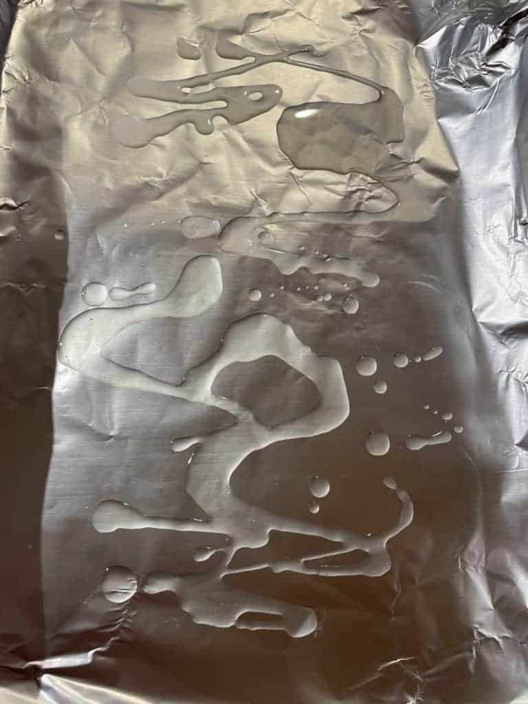 Olive oil drizzled on a foil lined baking sheet.
