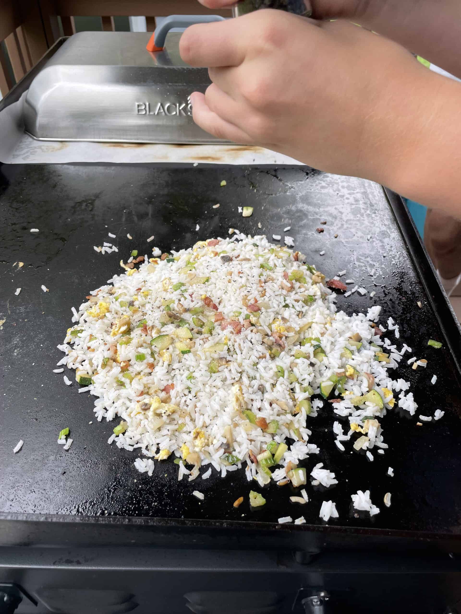 How to Make Chicken Fried Rice on a Blackstone Griddle with white rice, sautéed Vegetables, bacon, egg and seasonings.