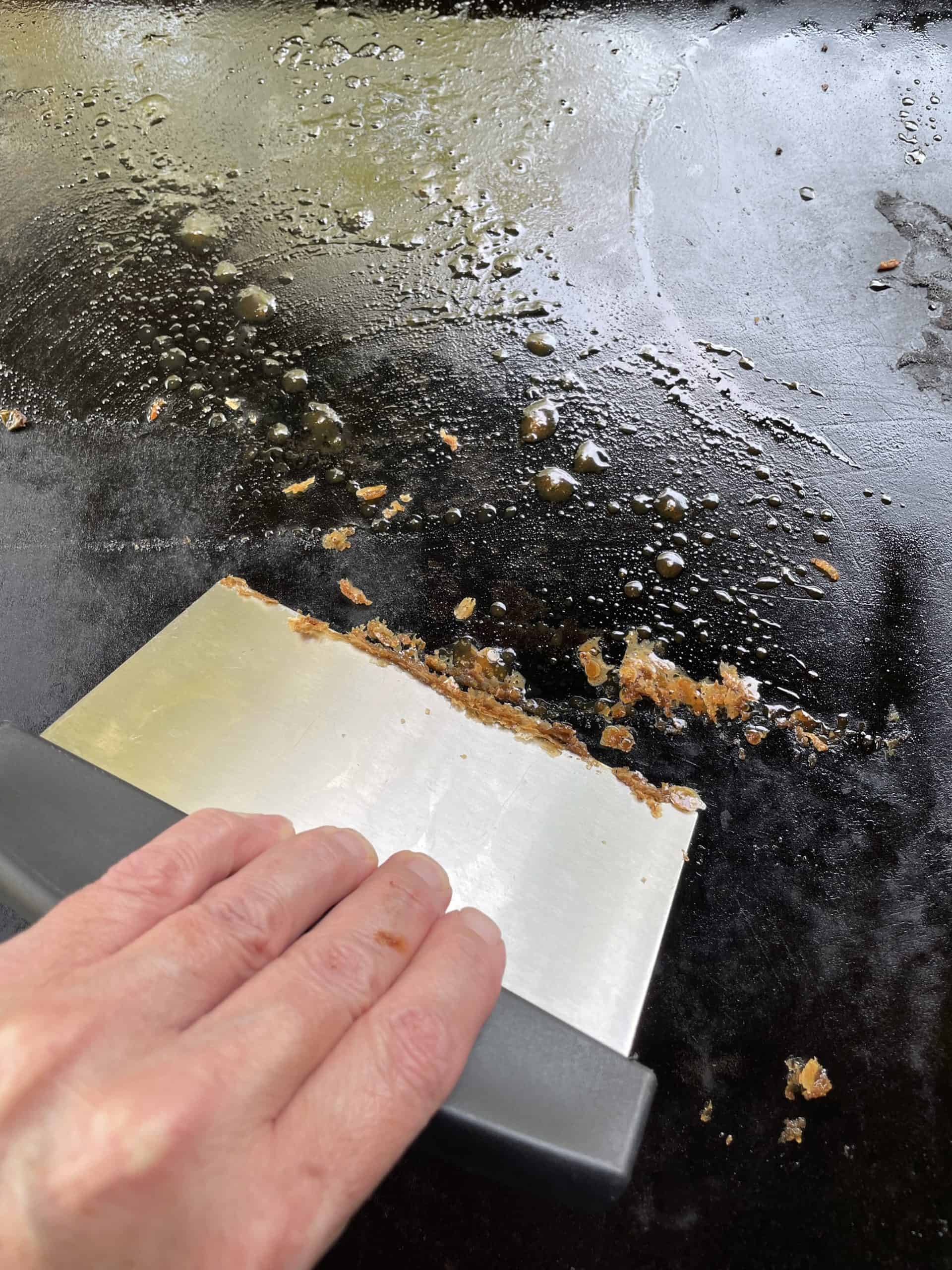 Use a bench scraper to clean off any food left on the griddle.
