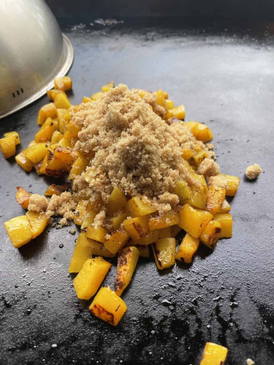 Add brown sugar to the top of griddle cooked butternut squash.