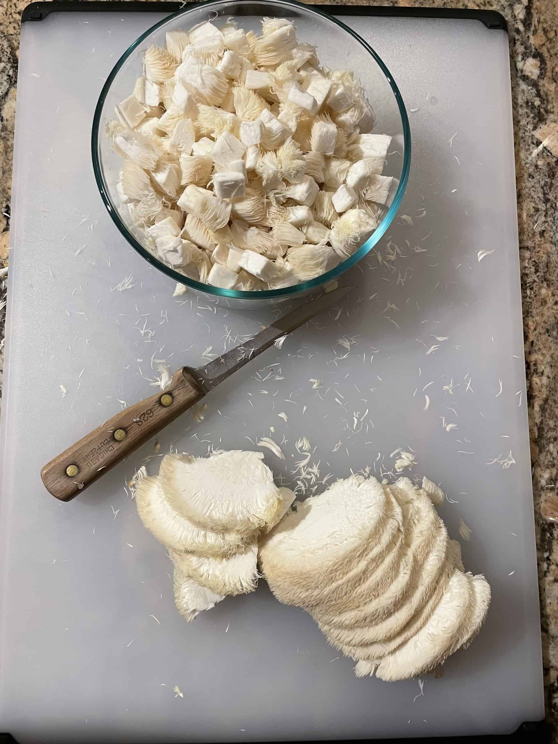 Diced and Slice Lion's Mane Mushrooms on a cutting board.
