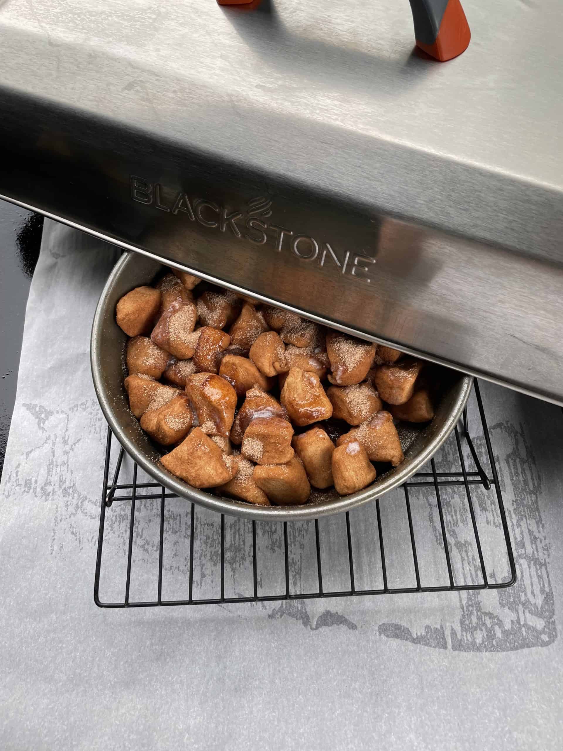 Dome covered Blackstone Griddle Monkey Bread dough on a cooking rack.