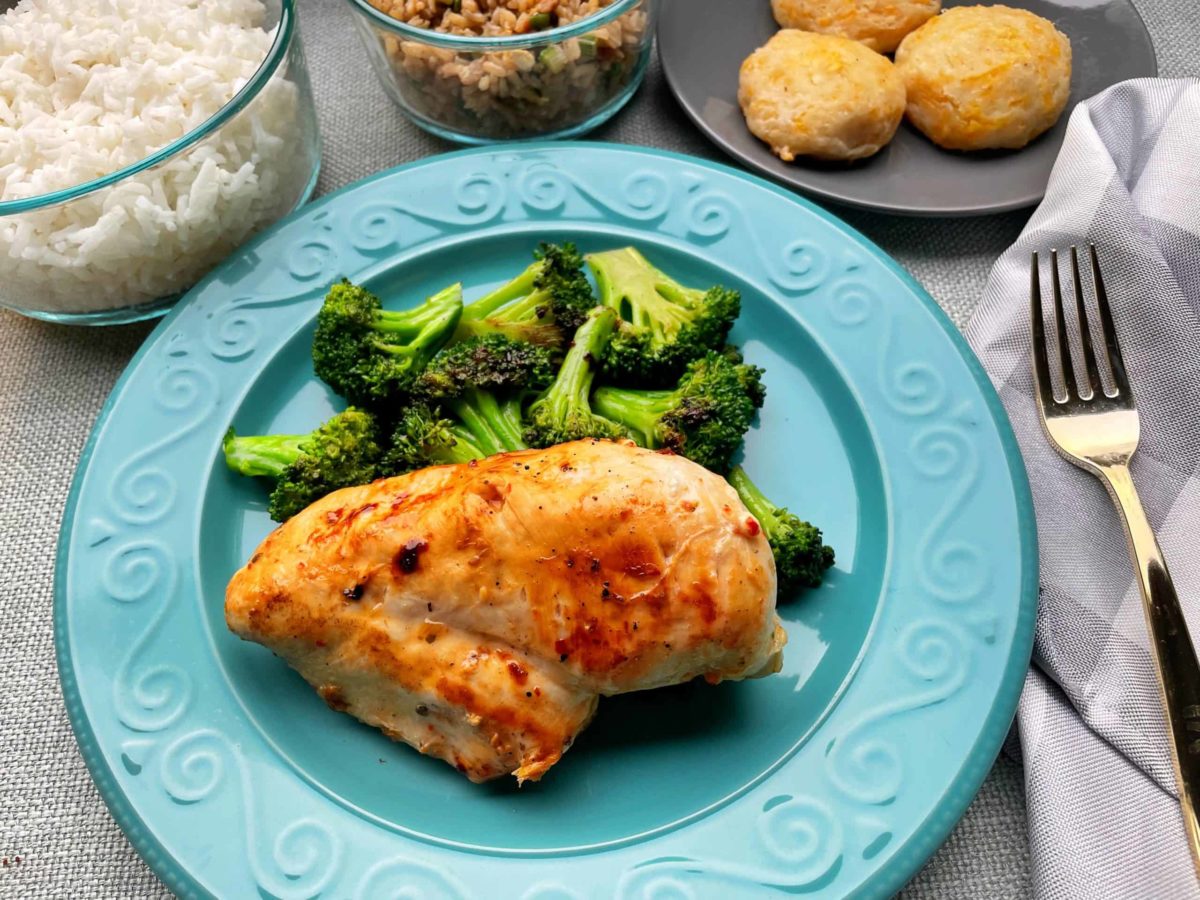 Easy Marinated Chicken Breast and Sauteed Broccoli on a Plate with an assortment of sides.