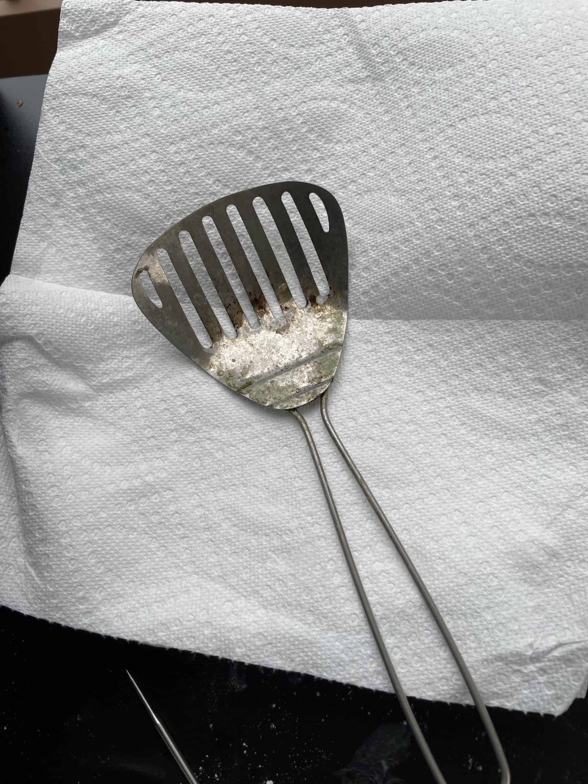 Metal Frying Spoon and a paper towel lined plate.