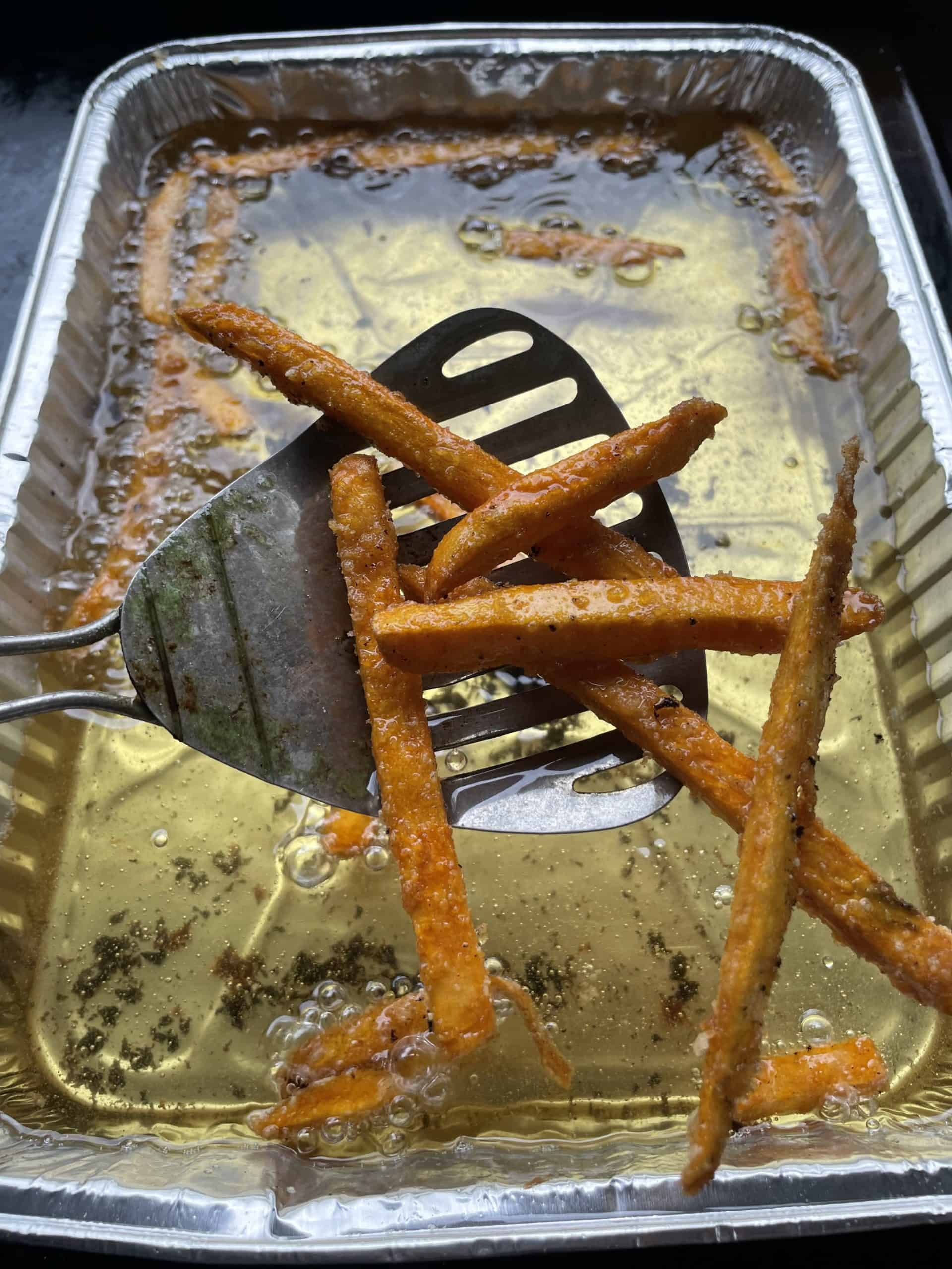 Fried Sweet Potato Fries on top of medal fry spoon.