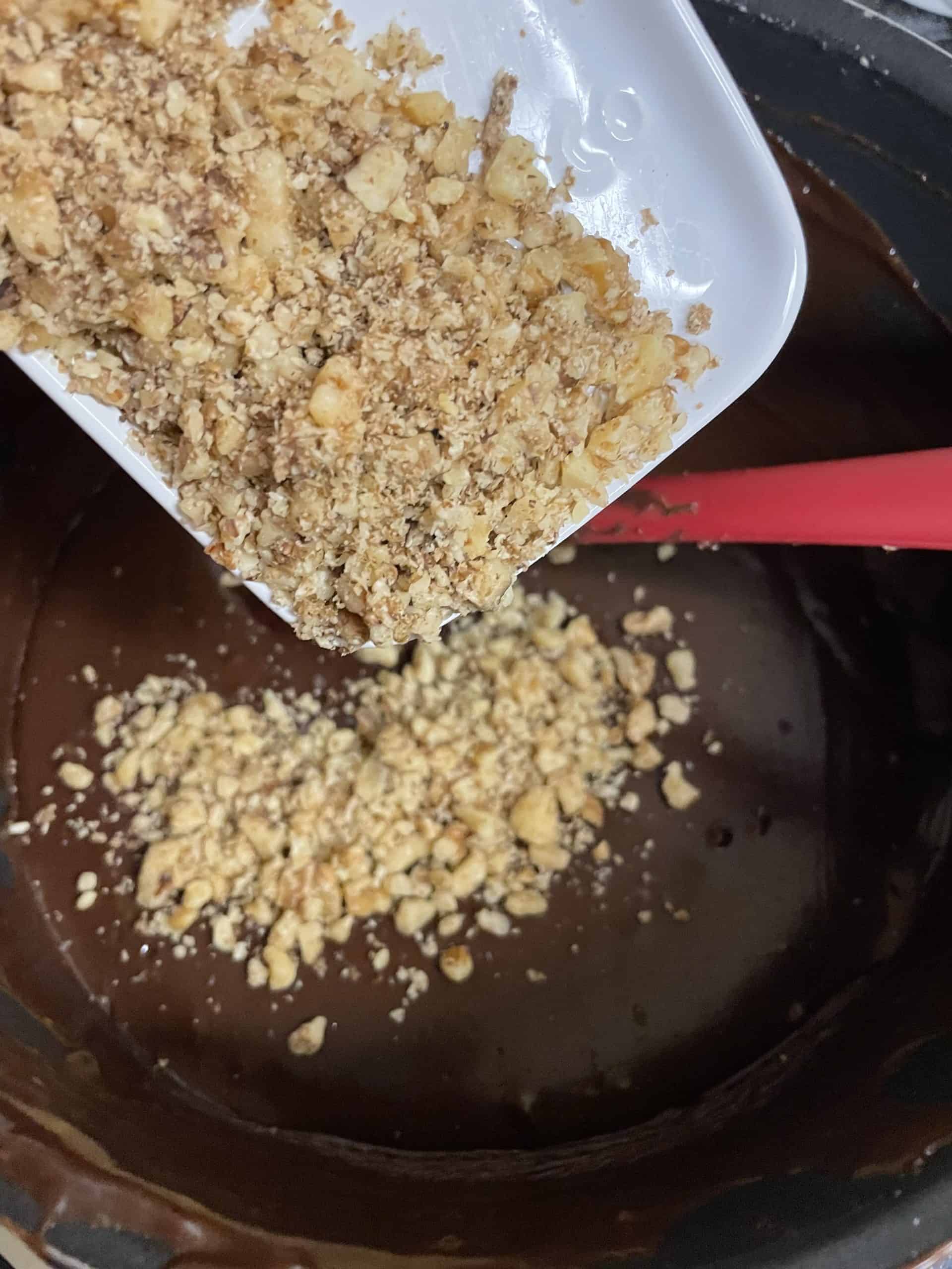 Pouring Nuts into Prepared Fudge.
