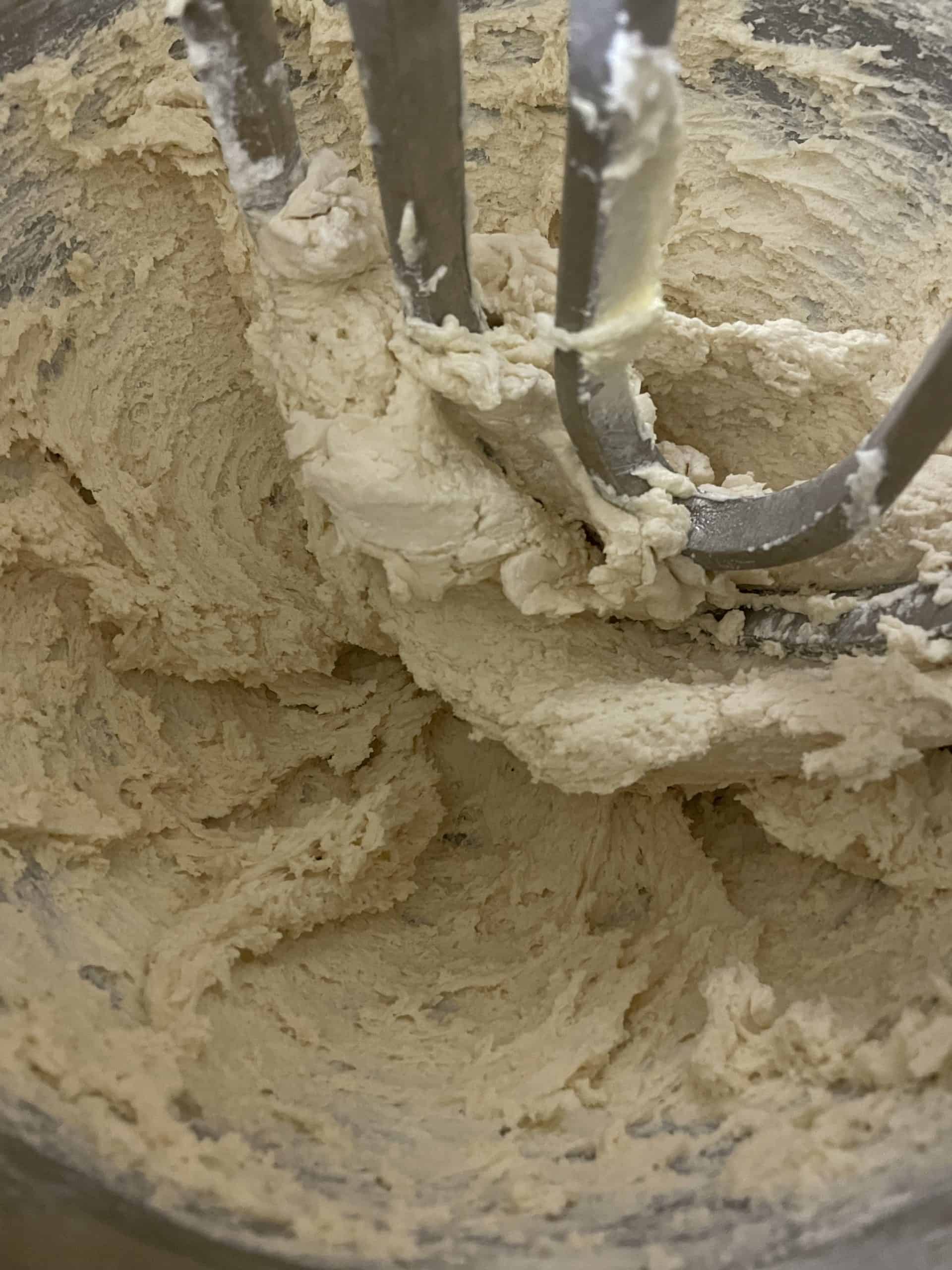 Creaming cookie dough ingredients together in a mixer.