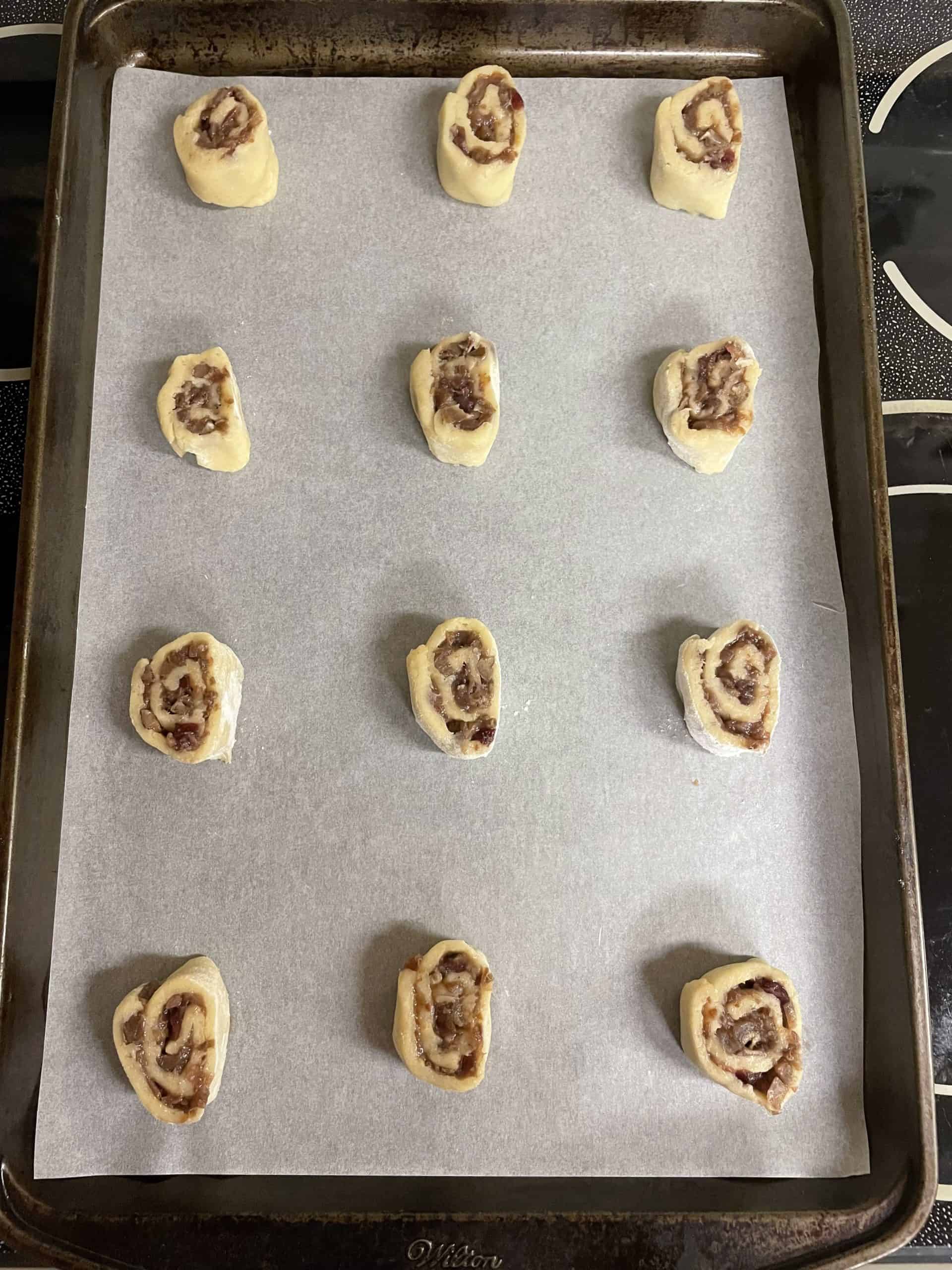 Unbaked Cranberry Pinwheel Cookies on a baking sheet.