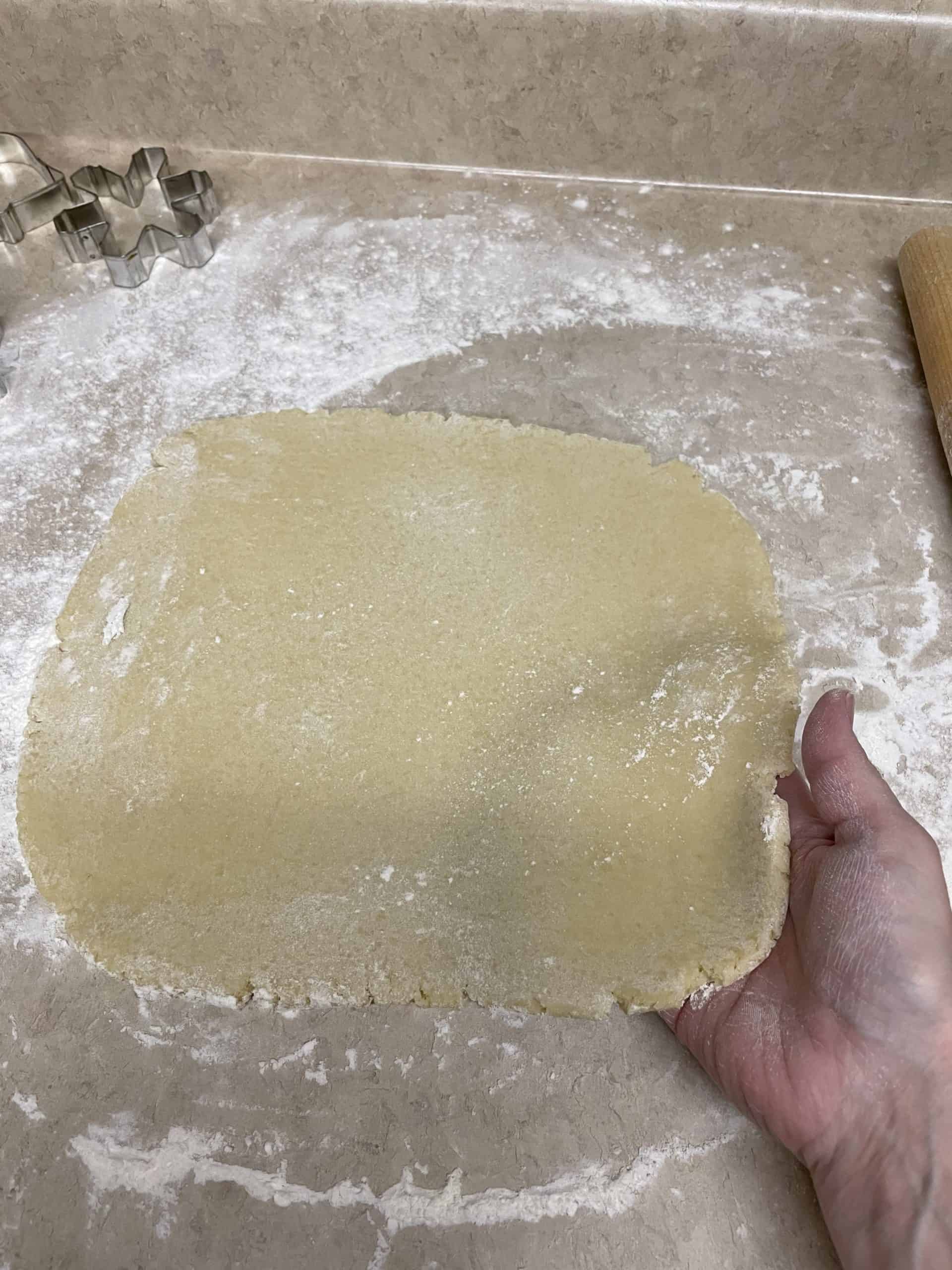 Make sure the sugar cookie dough is not sticking to the surface by placing your hand under the dough.