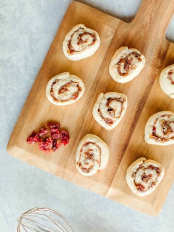 Cranberry Pinwheel Cookies on a wooden board.