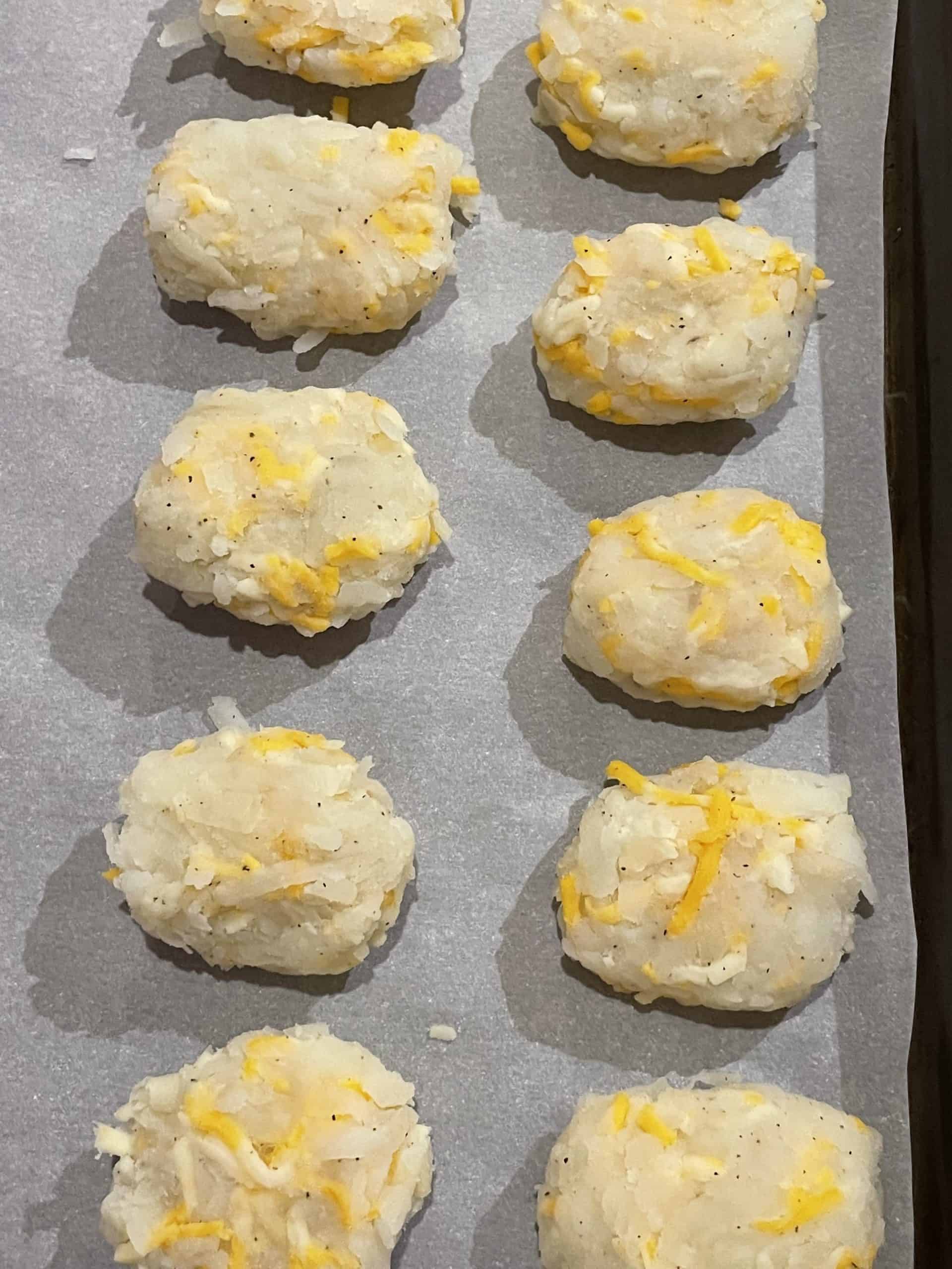 Formed Cheesy Tater Tots Recipe lined up on a sheet pan.
