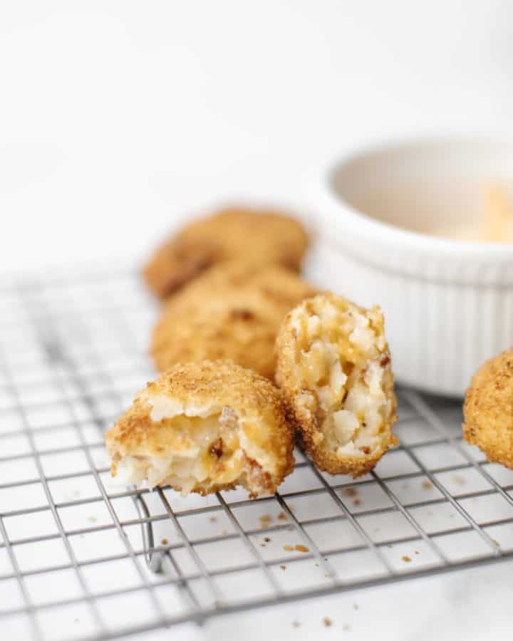 Cheesy Tater Tots Recipe on a cooling rack with shredded cheese.