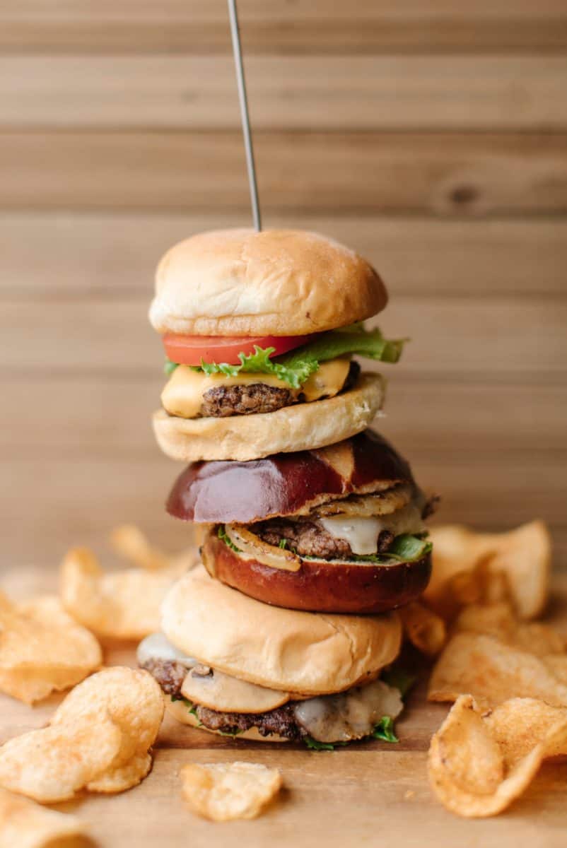 Blackstone Burger Tower on a wooden cutting board surrounded by kettle chips.