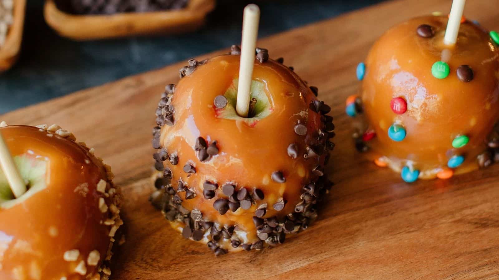 Professional Caramel Apples displayed on a wooden board.