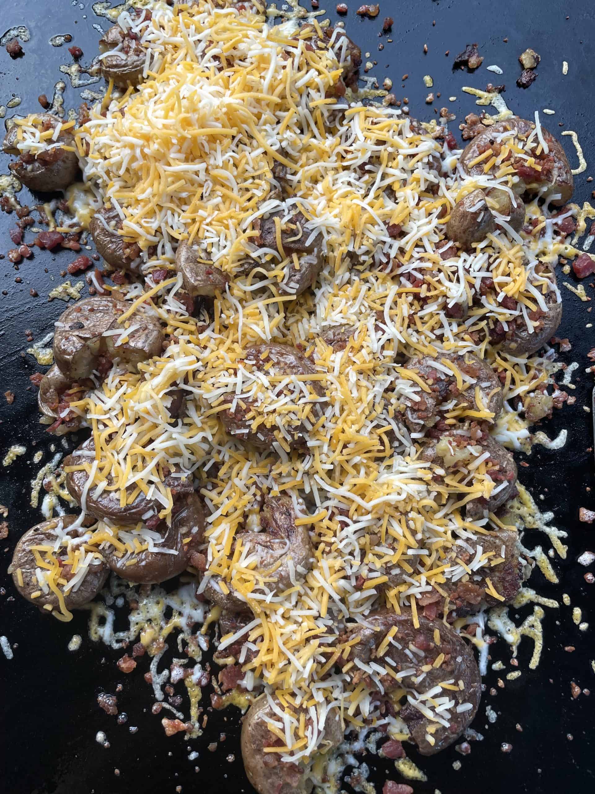 Top the bacon and potatoes with shredded cheese.