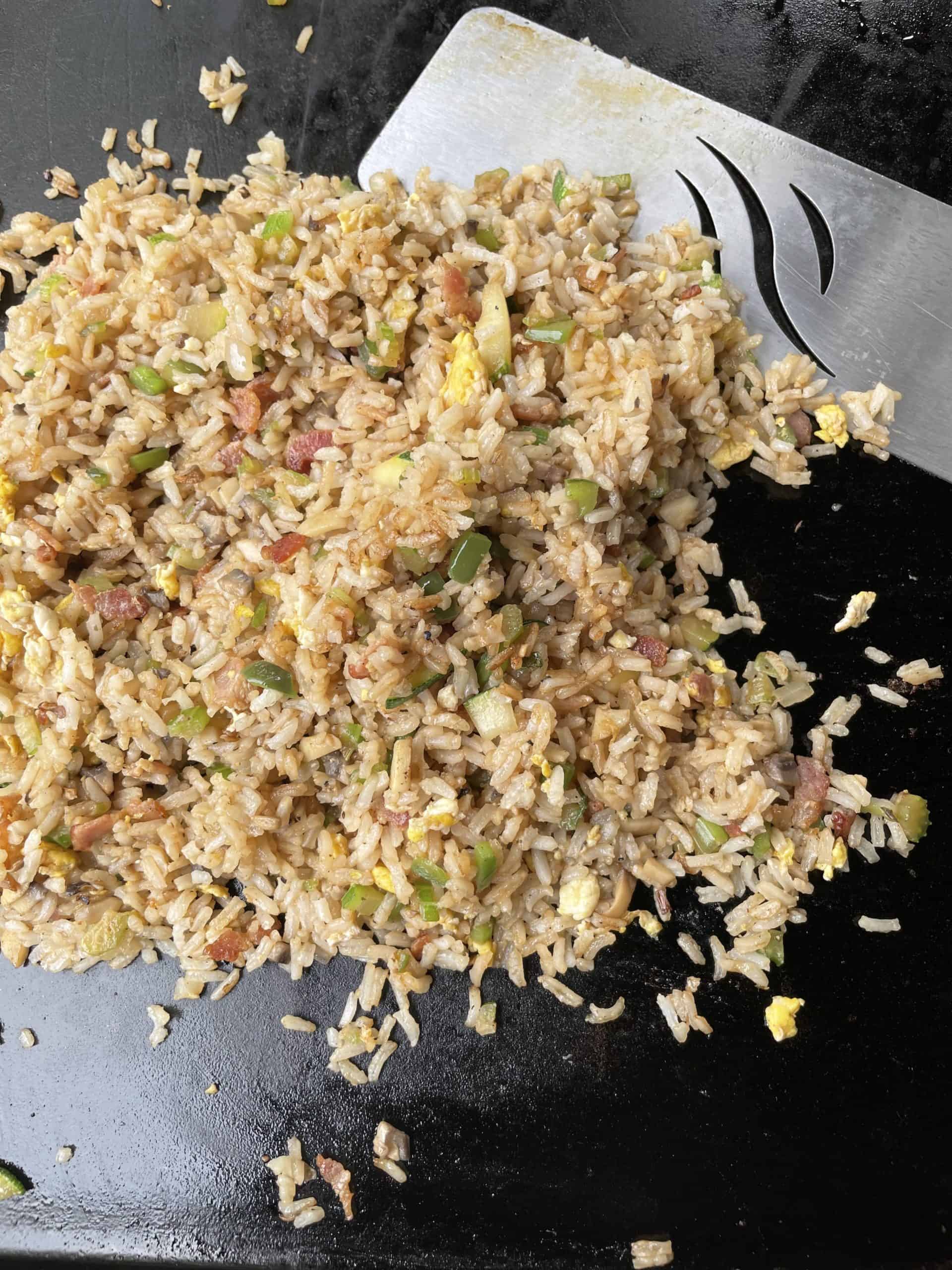 Fully cooked griddle fried rice with a griddle spatula.