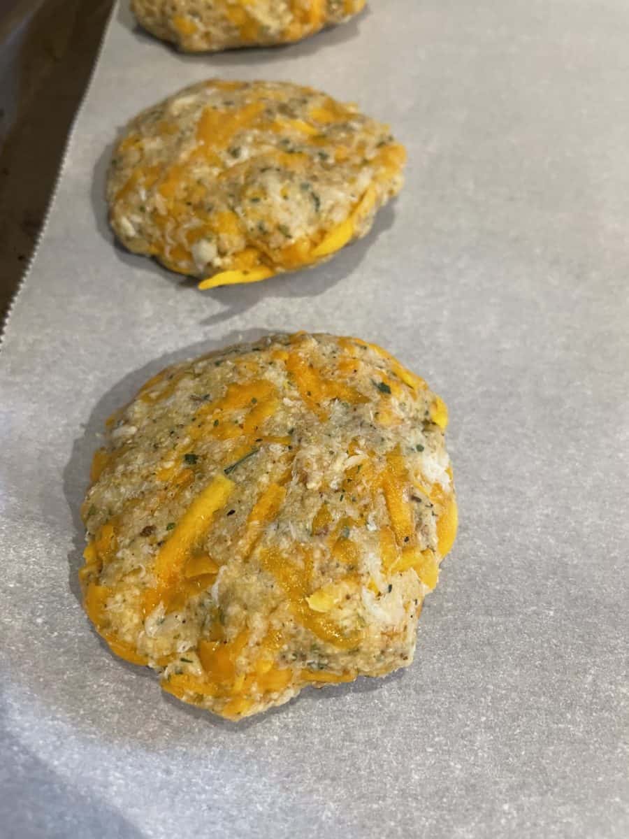 Uncooked Griddle Crab Cakes Patties on a piece of parchment paper.