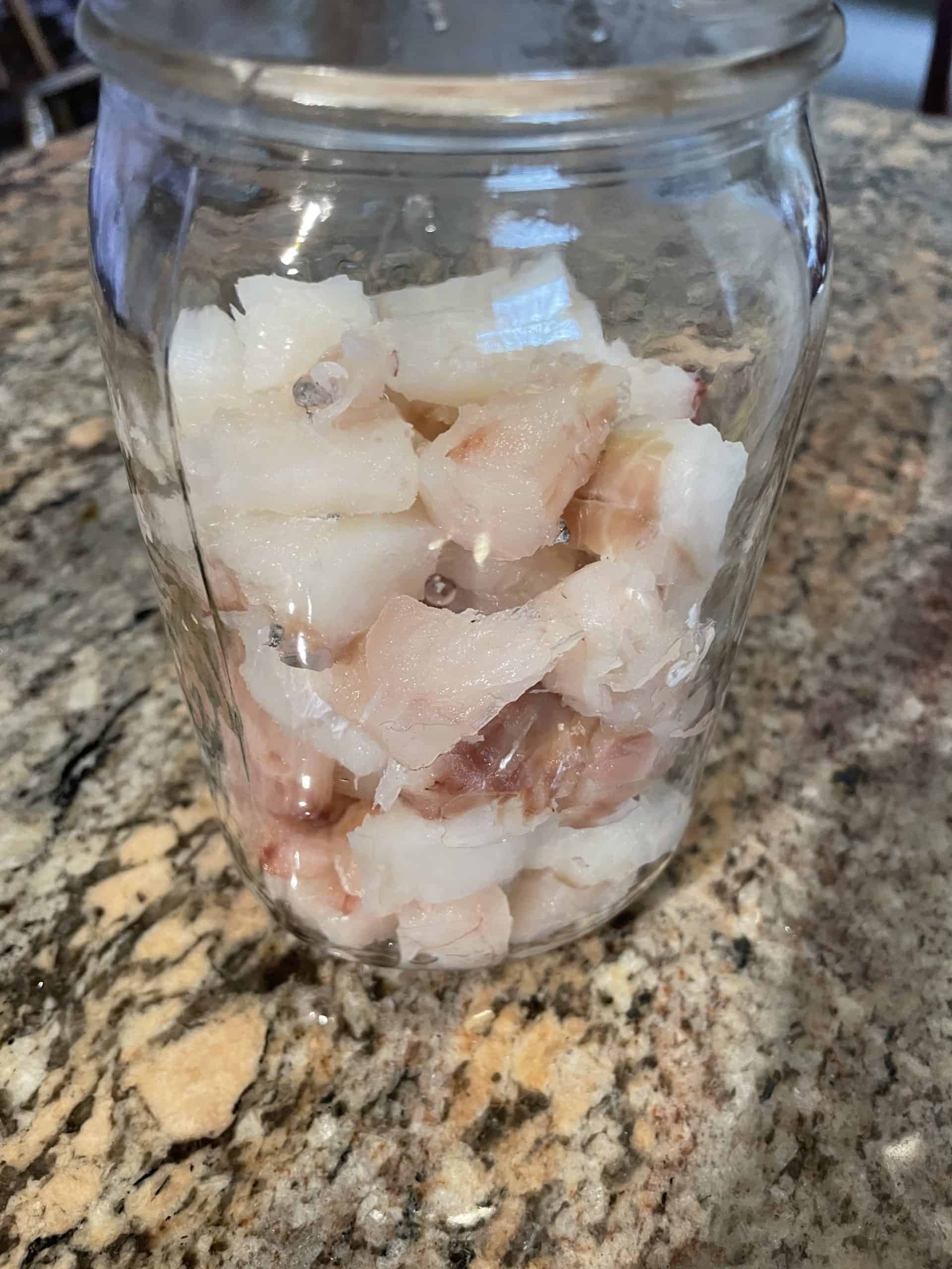 Glass jar with cod pieces.