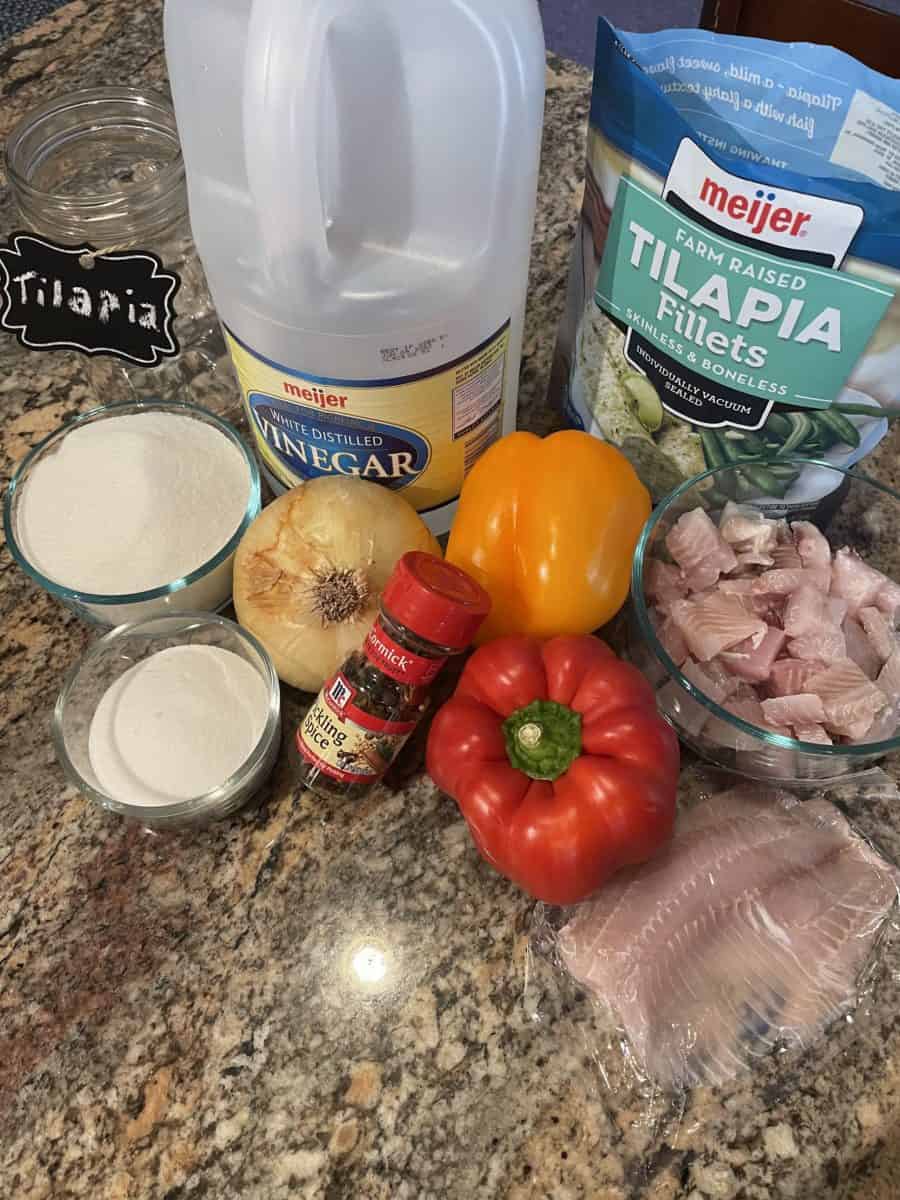 Pickled Tilapia Ingredients: tilapia pieces and chunks, bell peppers, onion, pickling spice, salt, sugar, and white vinegar.
