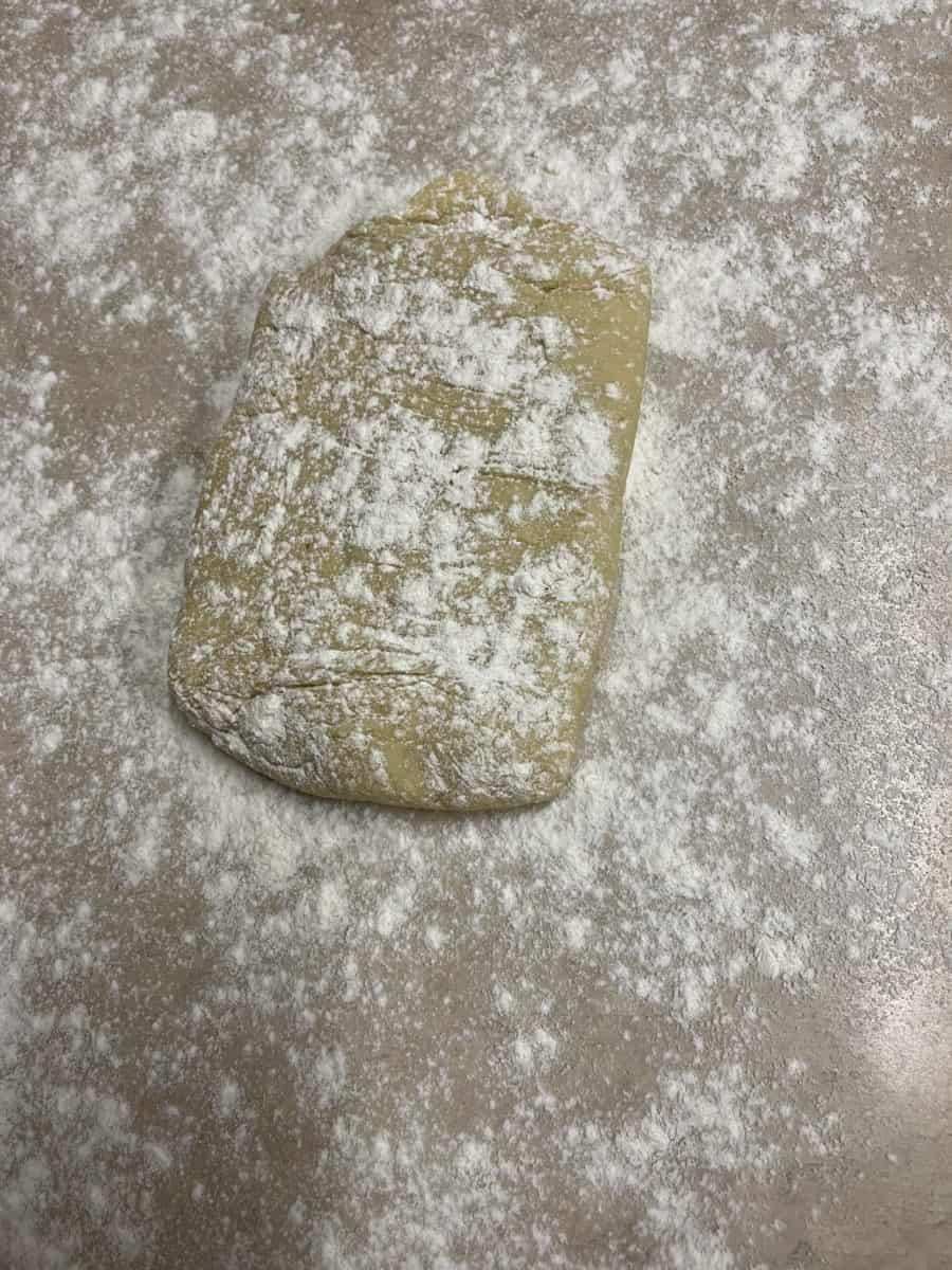Piece of Cookie Dough on a Floured Surface ready to be rolled out.