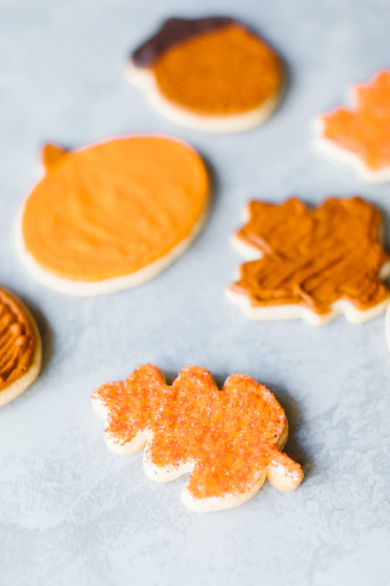 Pumpkin Spice Sugar Cookies (an assortment of fall cream cheese frosted cut out cookies on a mat).