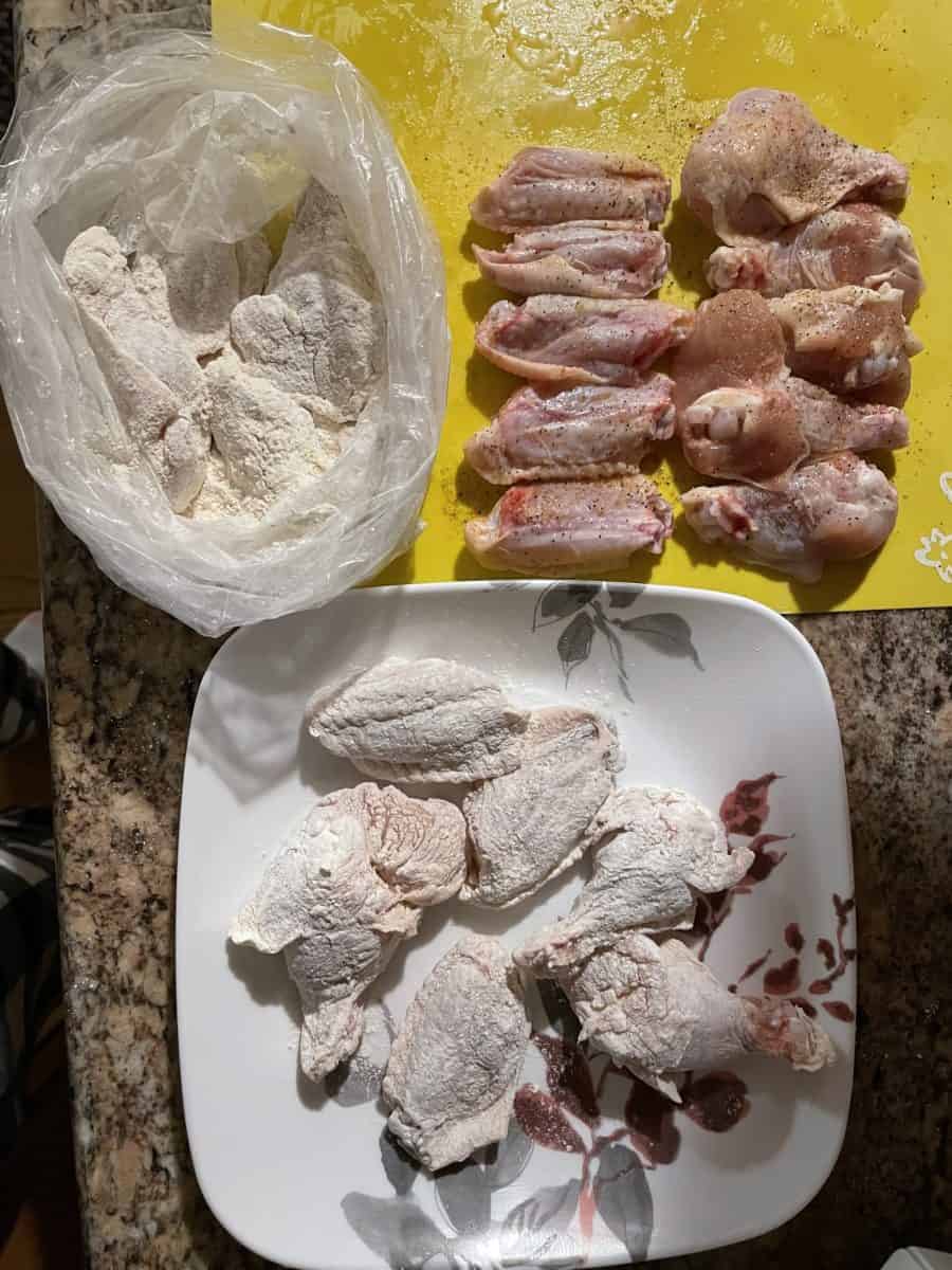 Steps to dredging chicken wings: place chicken pieces into a bag with Drakes fry mix, shake off excess mix and place on a plate.