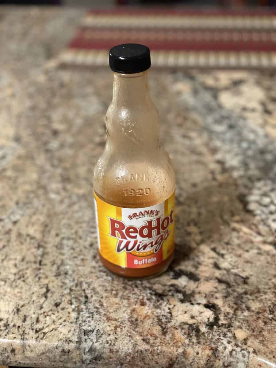 A bottle of Frank's RedHot Wings Buffalo Sauce on a countertop.