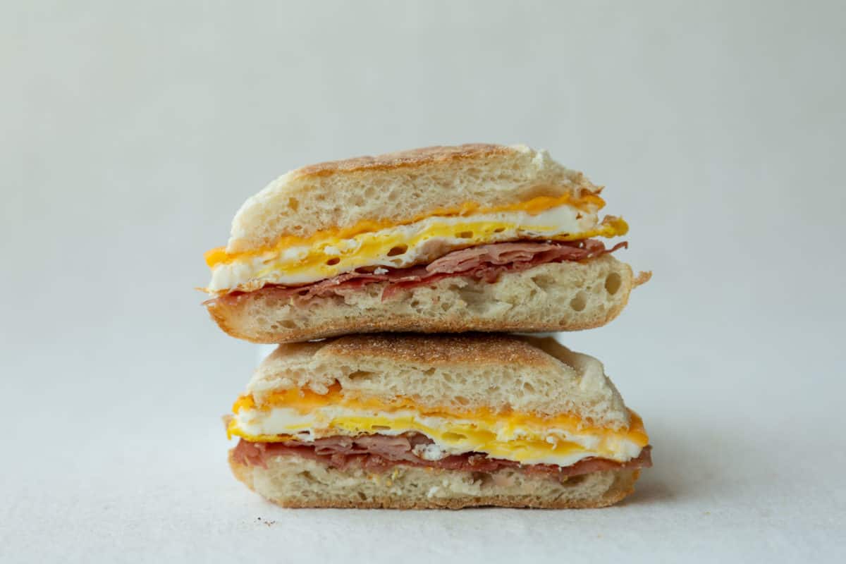 A Ham Egg and Cheese Sandwich cut in half and stacked.