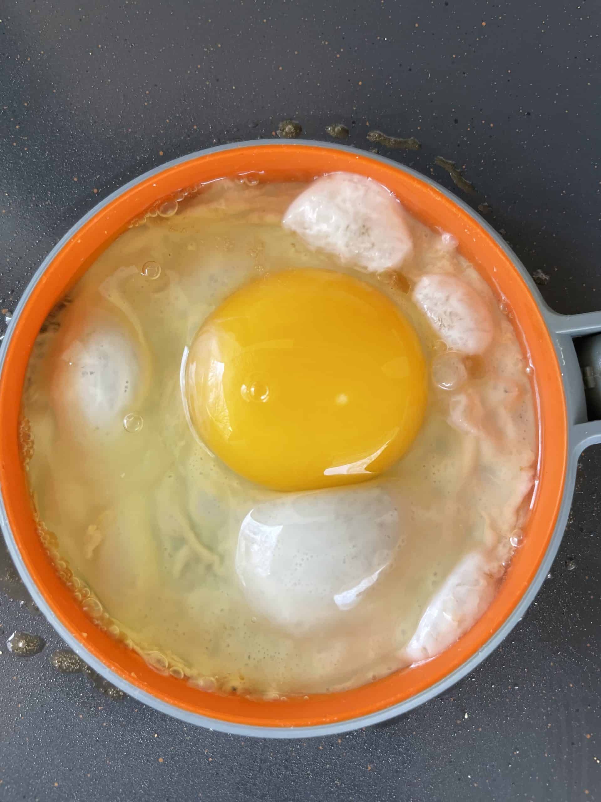 Crack a whole egg into the egg ring.