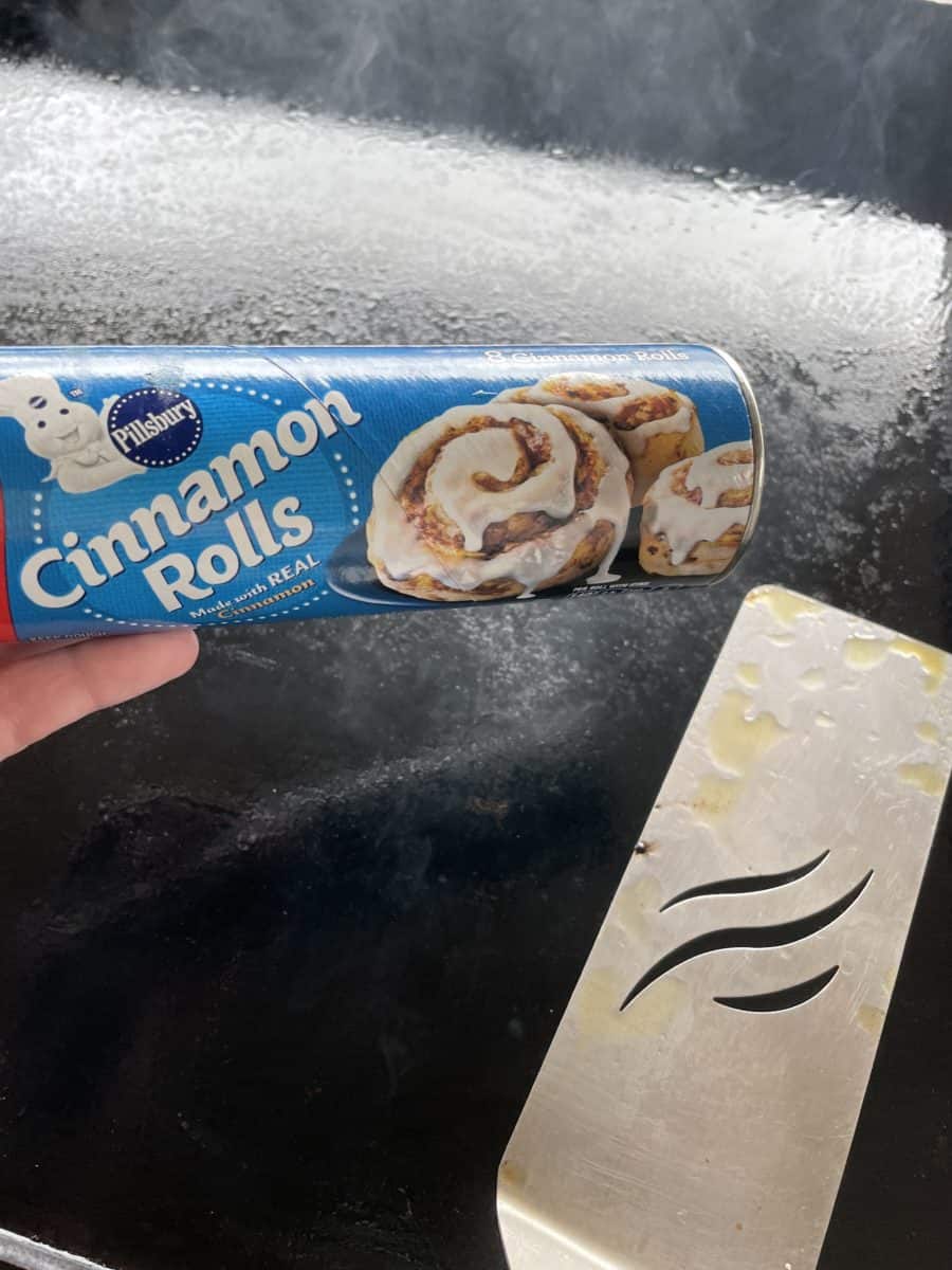 Pillsbury Cinnamon Rolls in a can bye a Blackstone Griddle with a griddle spatula.