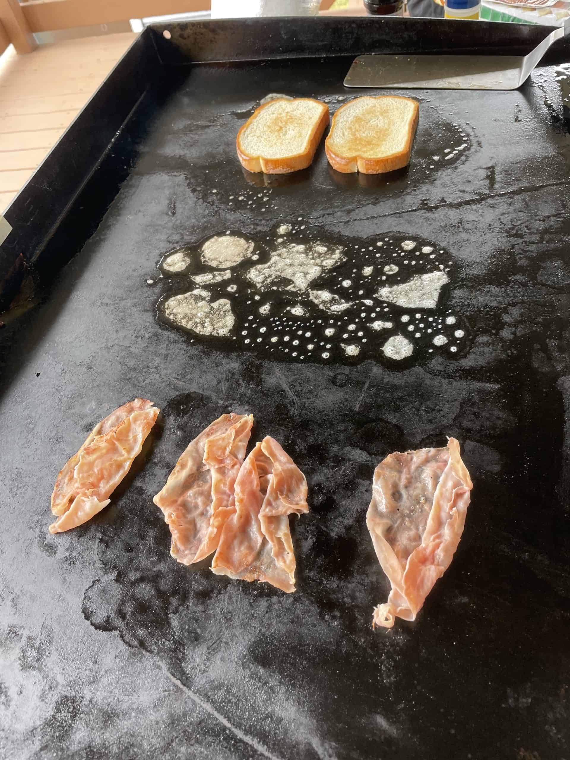 Griddle Bread and sliced ham cooking on a Blackstone Flat Top.