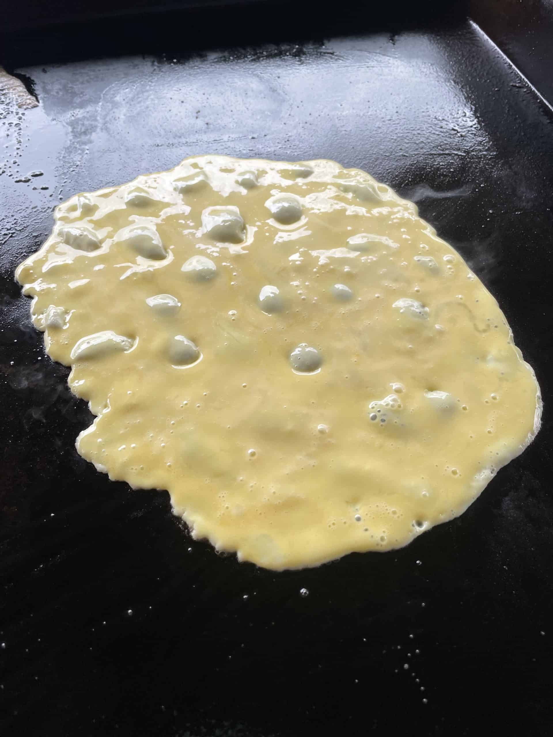 A Sheet of Scrambled Eggs cooking on a Blackstone Griddle.