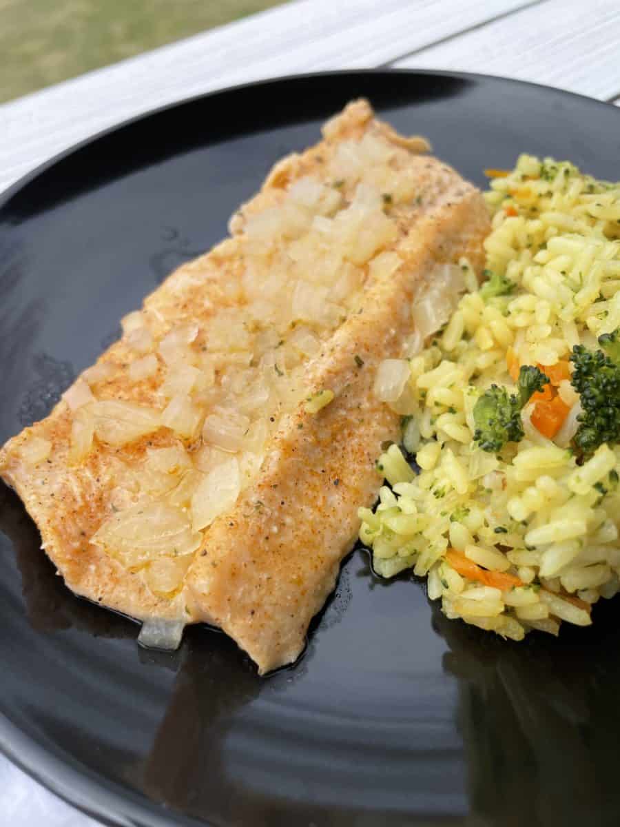 Baked Trout on a plate with vegetable rice.