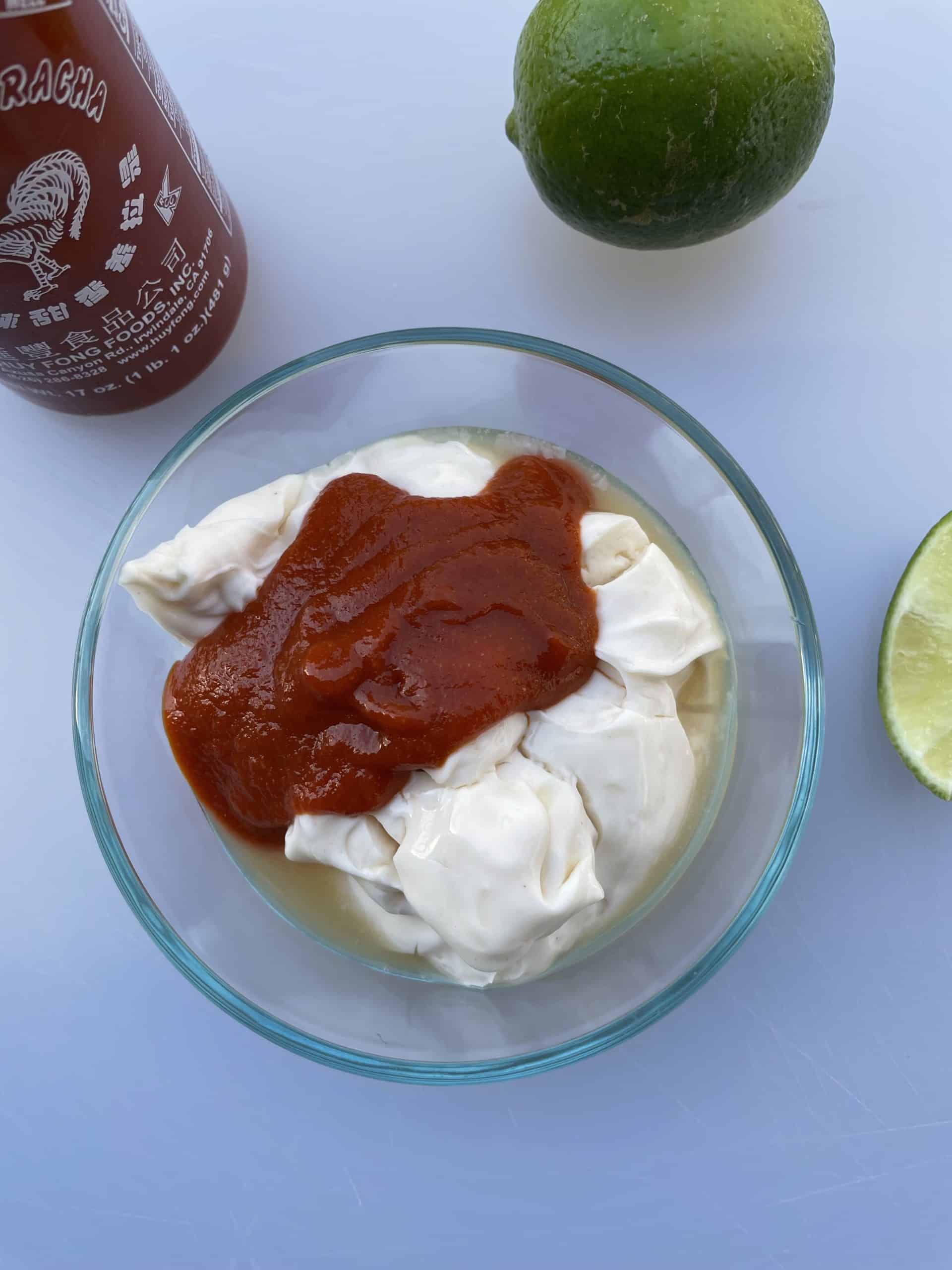 A bowl with mayo, sriracha and lime juice.