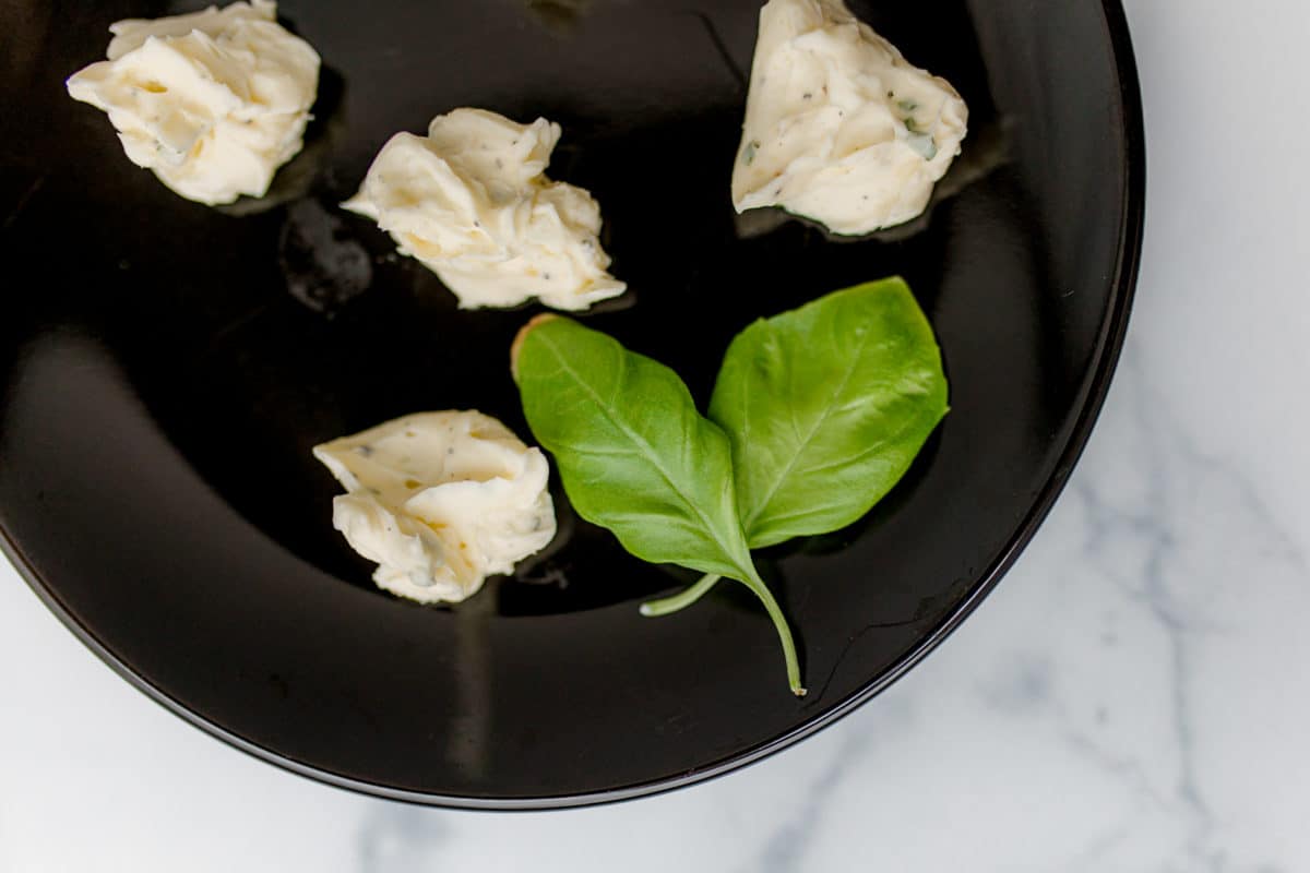 Basil Garlic Butter on a plate with  basil leaves.