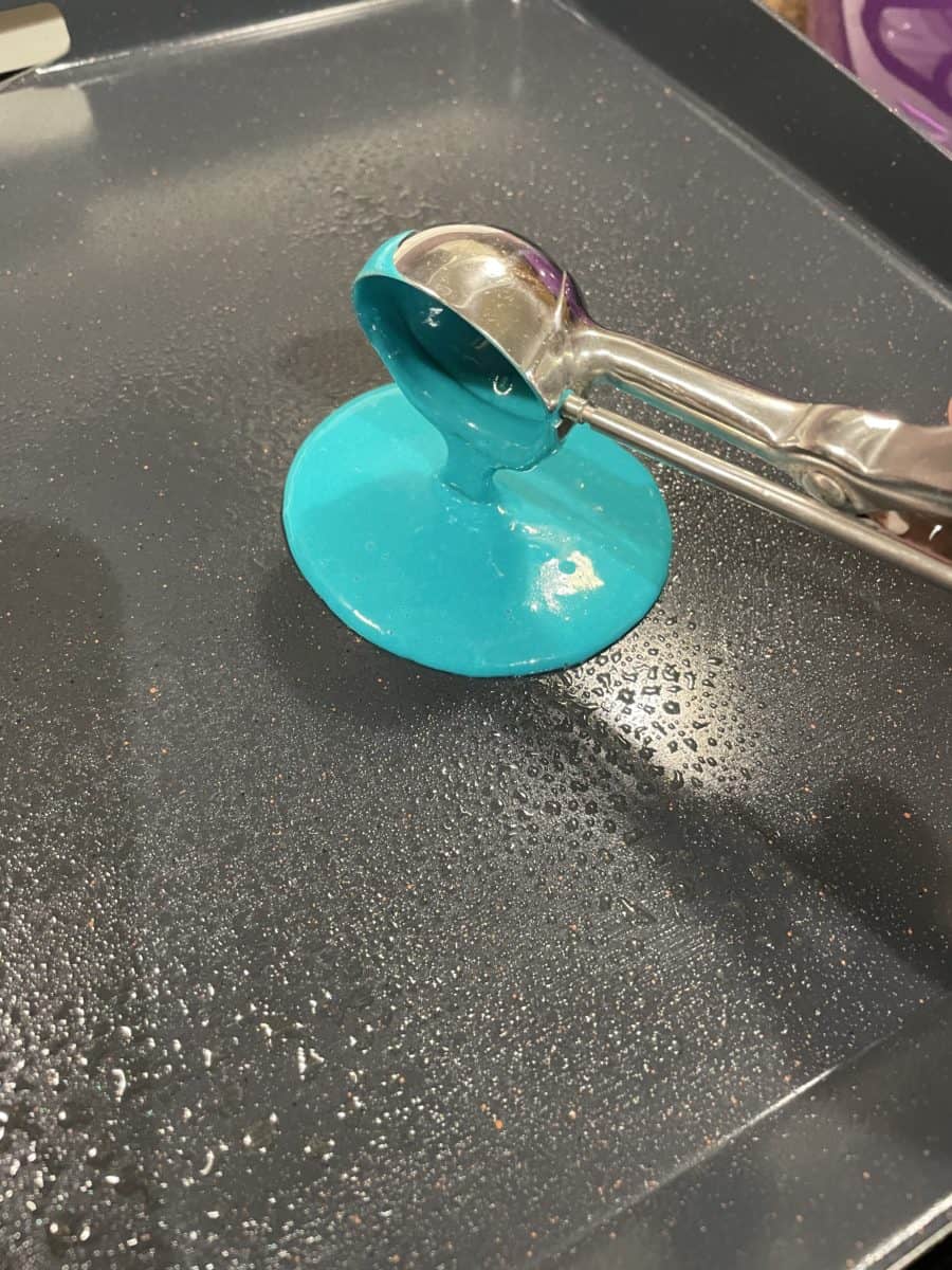 Using a #20 Scoop to Pour Blue Pancake Batter onto the Hot Griddle.