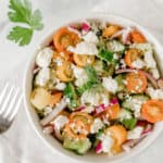 Cucumber Tomato Onion Salad with Feta in a white bowl.