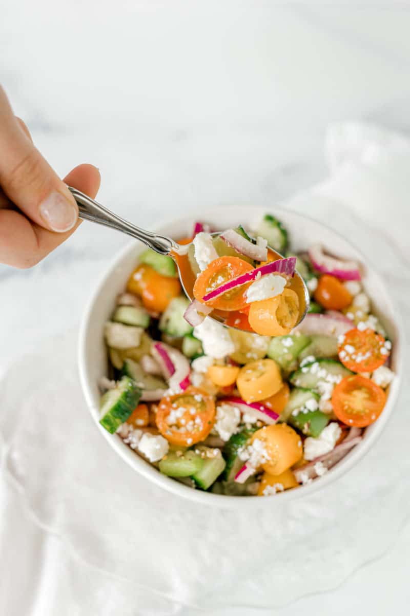 Tomato Cucumber Feta Salad in a bowl with a spoonful.