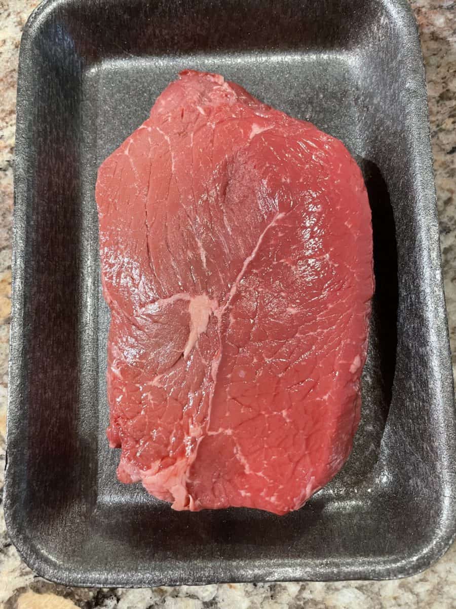 Top Sirloin Petite Steak on a black tray.