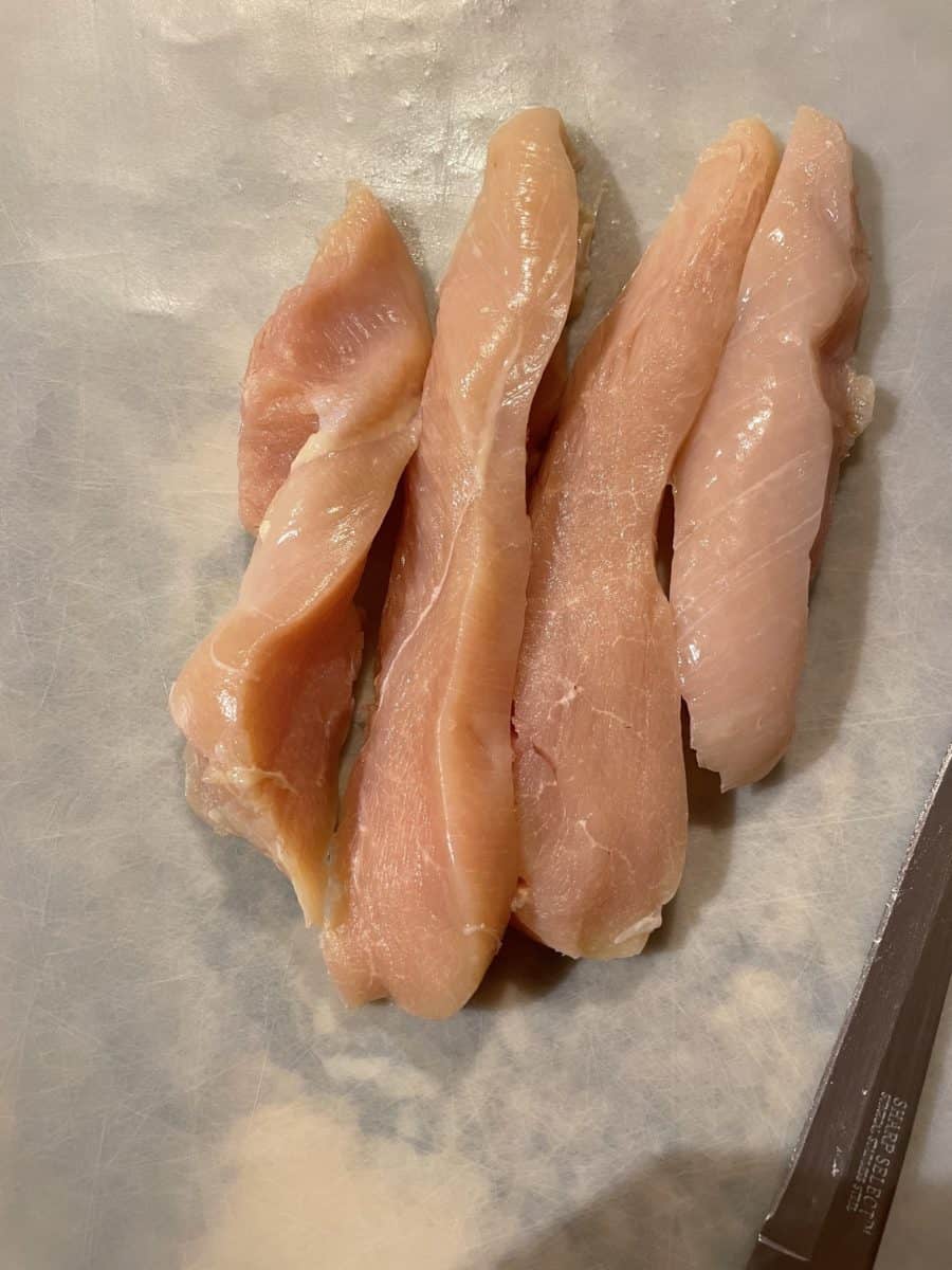 Chicken Breast Slices on a cutting mat.