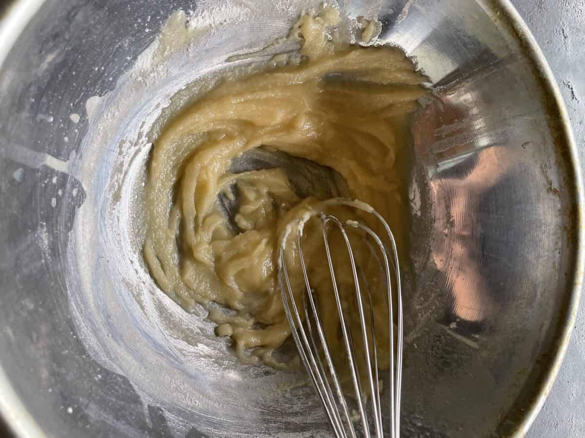 Making Roux with a Whisk in a Metal Bowl on top of a Blackstone Griddle.