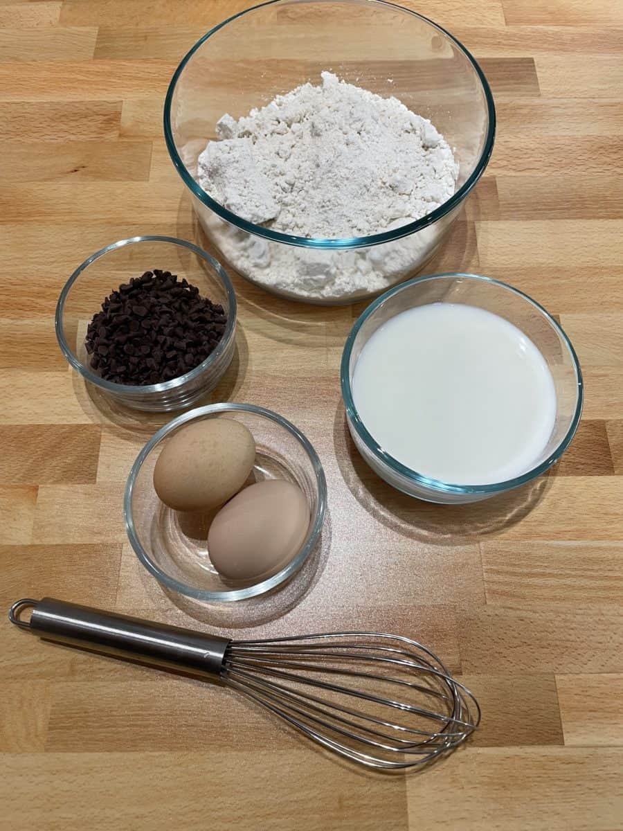 How to Make Chocolate Chip Pancakes Ingredients - Bisquick Pancake Mix, Milk, Eggs, and Chocolate Chips along with a whisk..