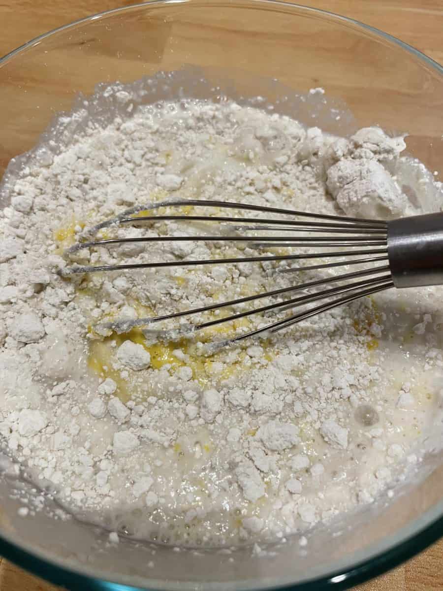 Using a whisk to mix up the homemade pancake mix in a bowl.