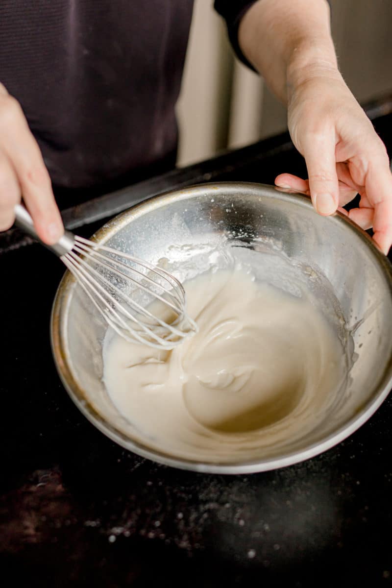 Continue Adding Milk while Whisking the Alfredo Sauce.