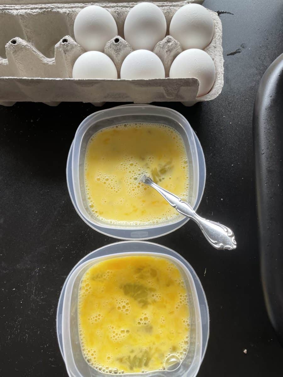 Scrambled Eggs on a bowl whipped with a fork along with a side of eggs.